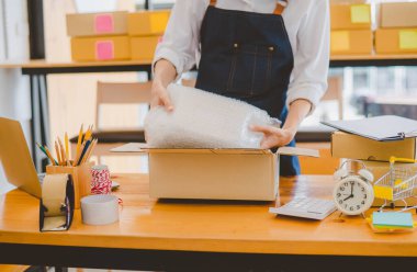 Online small business owners are packing their ordered products into the boxes for their customers based on the concept of online shopping - online shopping.