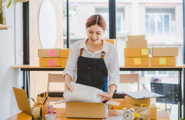 Online small business owners are packing their ordered products into the boxes for their customers based on the concept of online shopping - online shopping.