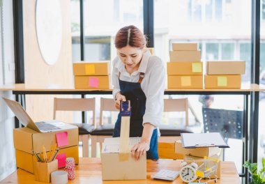 Online small business owners are packing their ordered products into the boxes for their customers based on the concept of online shopping - online shopping.
