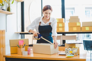 Online small business owners are packing their ordered products into the boxes for their customers based on the concept of online shopping - online shopping.