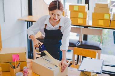 Online small business owners are packing their ordered products into the boxes for their customers based on the concept of online shopping - online shopping.