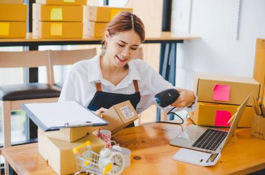Small business owners online are scanning barcode-labelled parcel boxes with a barcode scanner to verify their product orders. of online retailers - online shopping