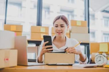 Small business owners online are writing their names and addresses to deliver products and products to their customers. and check the orders that the customers have ordered of online retailers - online shopping