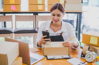 Small business owners online are writing their names and addresses to deliver products and products to their customers. and check the orders that the customers have ordered of online retailers - online shopping
