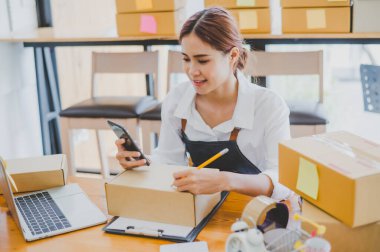 Small business owners online are writing their names and addresses to deliver products and products to their customers. and check the orders that the customers have ordered of online retailers - online shopping
