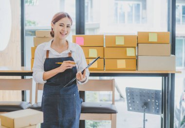 Small business owners online are smiling. and happy to work at a parcel delivery business offering orders and products to its customers online retailer - online shopping.