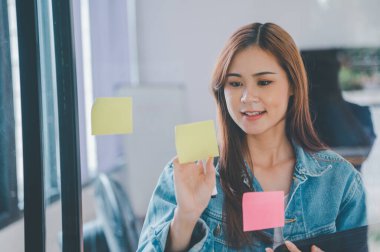 Web designers creating planning and analyzing with Colorful sticky notes on the office board.web design concept