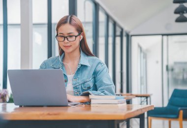 young student wearing small talk studies online, distance learning, and keeps up to date on the global coronavirus pandemic