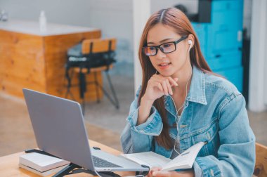 young student wearing small talk studies online, distance learning, and keeps up to date on the global coronavirus pandemic