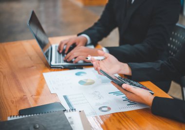 Analiz, kavramsal analiz ve iş planlaması için grafik şarj ederek ofiste birlikte çalışan ve iletişim kuran bir grup iş adamı