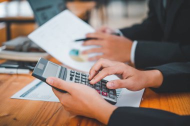 Analiz, kavramsal analiz ve iş planlaması için grafik şarj ederek ofiste birlikte çalışan ve iletişim kuran bir grup iş adamı