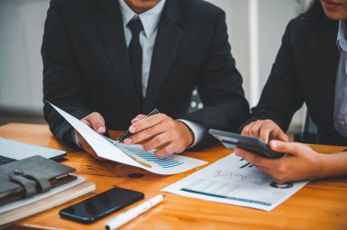 Analiz, kavramsal analiz ve iş planlaması için grafik şarj ederek ofiste birlikte çalışan ve iletişim kuran bir grup iş adamı