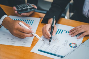 Analiz, kavramsal analiz ve iş planlaması için grafik şarj ederek ofiste birlikte çalışan ve iletişim kuran bir grup iş adamı