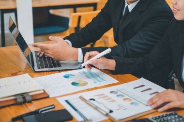 Analiz, kavramsal analiz ve iş planlaması için grafik şarj ederek ofiste birlikte çalışan ve iletişim kuran bir grup iş adamı