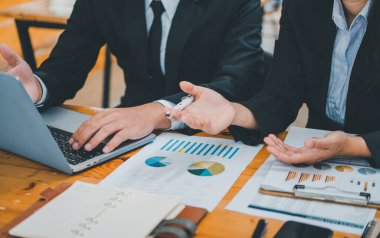 Analiz, kavramsal analiz ve iş planlaması için grafik şarj ederek ofiste birlikte çalışan ve iletişim kuran bir grup iş adamı