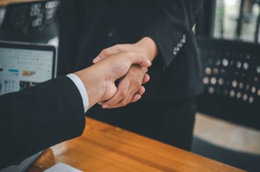 İş adamları, sözleşmenin başarıyla tamamlanmasını kutlamak için el sıkışıyor.