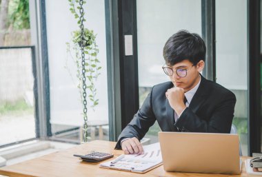 Analiz, kavramsal analiz ve iş planlaması için grafik ücretlendirmesi ile ekip toplantısında video üzerinden çalışan işadamı
