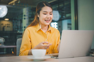 young student wearing headphones studies online, distance learning, and keeps up to date on the global coronavirus pandemic.