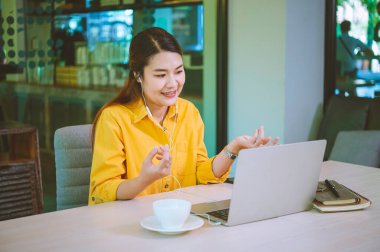 young student wearing headphones studies online, distance learning, and keeps up to date on the global coronavirus pandemic.