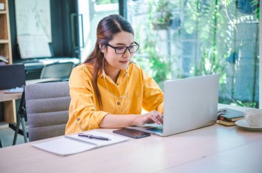 İş kadını internette bir kafede dizüstü bilgisayarla çalışıyor..