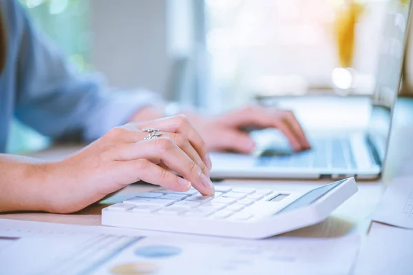 Business asian woman sitting at a desk at an office By using the calculator to work. Business Concept Analysis and Planning