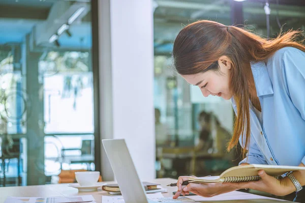 İş raporunda kalemle işaret eden işadamı, iş analizinde grafikler ve belgelerle birlikte hesaplar üzerinde çalışıyor.