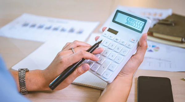 Business asian woman sitting at a desk at an office By using the calculator to work. Business Concept Analysis and Planning