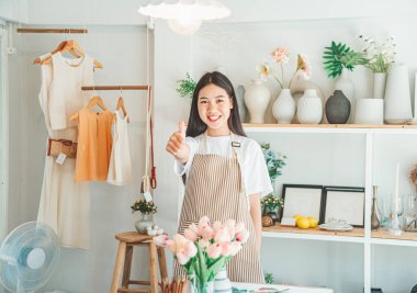 Küçük işletme sahipleri müşterileri karşılamak ve internet üzerinden müşterileri elde etmek için küçük dükkanlarında gülümsüyorlar. Müşterilerin çevrimiçi perakendecilerden sipariş ettikleri siparişleri de kontrol et..