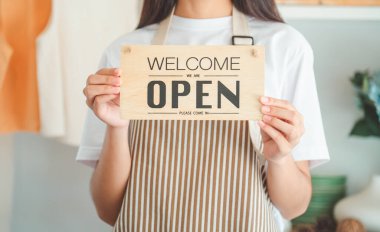Smiling online small business owner holding a sign saying 