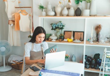 Küçük işletme sahipleri ürünleri denetliyor ve müşterilerle konuşup online perakendecilerden sipariş alıyor..