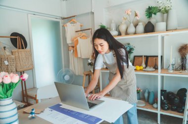 Küçük işletme sahipleri ürünleri denetliyor ve müşterilerle konuşup online perakendecilerden sipariş alıyor..