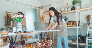 Küçük işletme sahipleri ürünleri denetliyor ve müşterilerle konuşup online perakendecilerden sipariş alıyor..