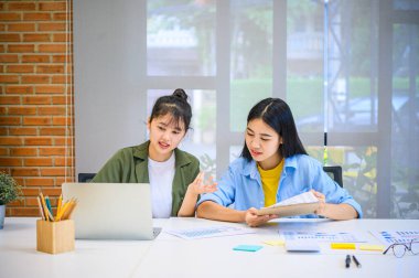 Analiz, kavramsal analiz ve iş planlaması için grafik şarj ederek ofiste birlikte çalışan ve iletişim kuran bir grup iş adamı