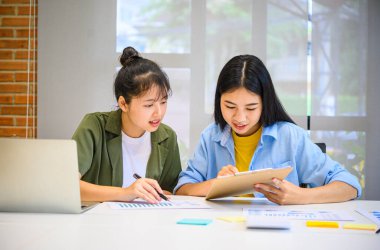 Analiz, kavramsal analiz ve iş planlaması için grafik şarj ederek ofiste birlikte çalışan ve iletişim kuran bir grup iş adamı