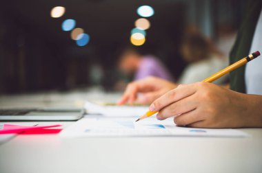 Grafikli belgeler üzerinde çalışan serbest çalışan bir işçi. ve kafelerdeki dizüstü bilgisayarların mali durumu hakkında bilgi