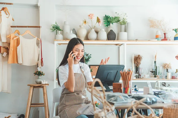 Small business owner talking on the phone with customers in a small shop. and check orders, check the orders that customers order from online retailers - online shopping