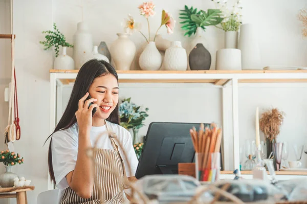 Small business owner talking on the phone with customers in a small shop. and check orders, check the orders that customers order from online retailers - online shopping