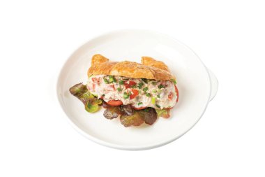 Ton balıklı kruvasan sandviçi beyaz tabağa koyun.