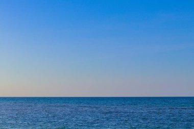 Güneş yansımalı mavi okyanus manzarası berrak gökyüzü, dalgalı deniz ve güzel güneş ışığı ile sakin deniz.