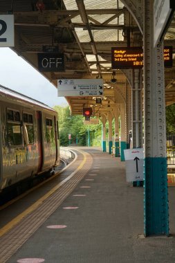 Cardiff, Wales - 20 Ağustos 2021: Galler 'de koruyucu yüz maskeleri hala zorunludur ve Queen Street Cardiff istasyonundaki yolcuların çoğu seyahat ederken yüzlerinin kapalı olduğundan emin olur.