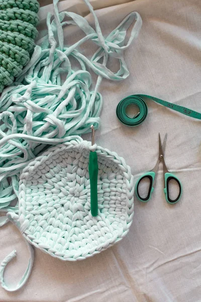 Crocheted bag, yarn, scissors, centimeter. Mint colors. Background for content. Knitting. Hobby. Flatley.