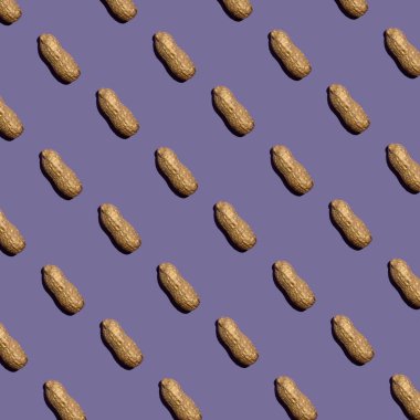 Leylak arka planında yer fıstığı deseni. Düz yatıyordu. Asgari konsept.