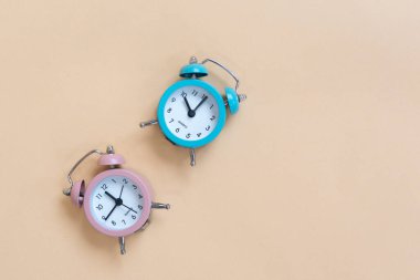 Bej arkaplanda mavi ve pembe alarmlı saat
