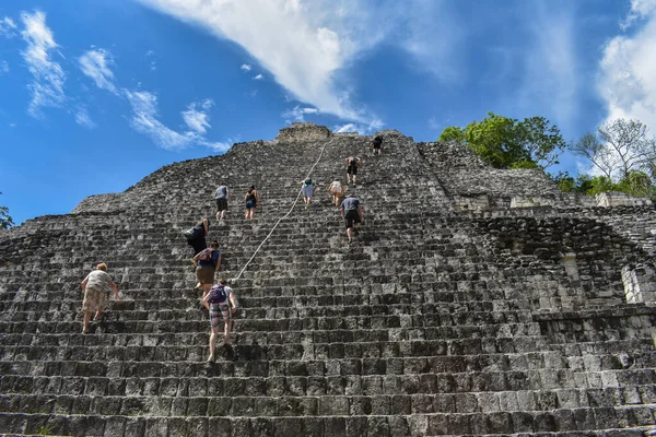 Bir grup turist Becn 'deki uzun Maya piramidine tırmanıyor.