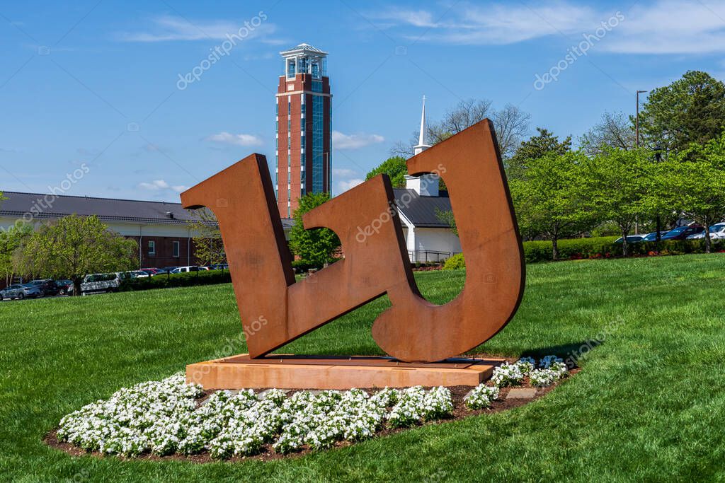 Lynchburg, Virginia - April 22, 2022: Large metal logo for Liberty University with the Freedom tower in the background . Freedom tower is part of the John W. Rawlings School of Divinity.