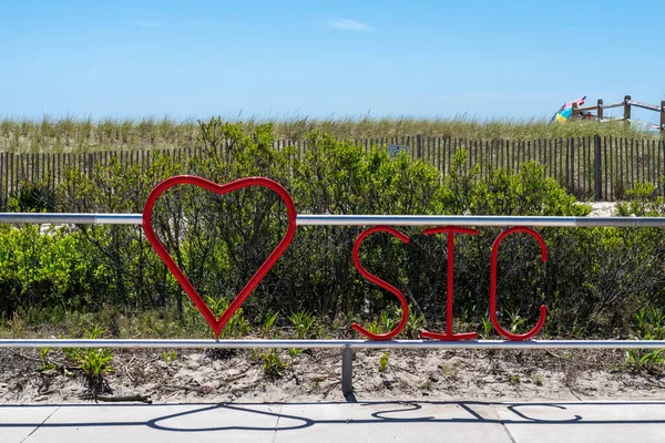 Sea Isle City, New Jersey 'de plaj kumulu ve arkasında eskrim olan bir kalp tırabzanı.
