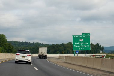 Lehighton, PA - July 28, 2022: Mahoning Valley Exit 74 sign on the Northeast Extension of the Pennsylvania Turnpike for Lehighton and Stroudsburg Route 209. clipart