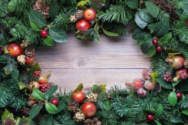 Noel yeşillik arka planında kırsal ahşap üzerinde ışıltılı elma süslemeleri