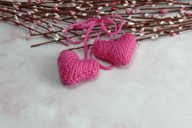 Pembe mermer arka planda bahar çiçeği tomurcuklarıyla örülmüş pembe kalpler.