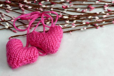 Pembe mermer arka planda bahar tomurcuğu dallarıyla örülmüş iki kalbi kapatın.